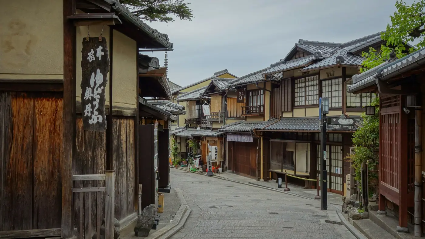 A quiet Kyoto street lined with traditional wooden townhouses